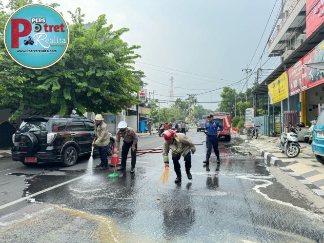 
 Sigap, Polisi bersama Damkar Bersihkan Tumpahan Solar di Jalan Raya Lamongan Antisipasi Kecelakaan